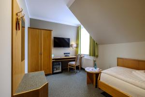een hotelkamer met een bed en een bureau met een computer bij Flair Hotel Kamenz in Kamenz