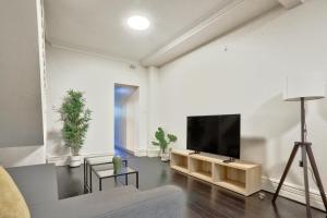 uma sala de estar com uma televisão de ecrã plano na parede em Spacious 3 Bedroom House Glebe with 2 E-Bikes Included em Sydney