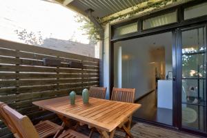 einen Holztisch und Stühle auf einer Terrasse in der Unterkunft Spacious 3 Bedroom House Glebe with 2 E-Bikes Included in Sydney