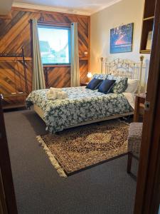 a bedroom with a bed with blue pillows and a window at Whitemore B&B 