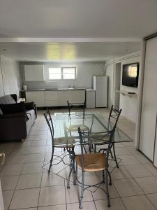 - un salon avec une table et des chaises en verre dans l'établissement Bel appartement de 60 m2, à Rosières-près-Troyes
