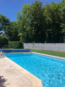 - une piscine d'eau bleue dans la cour dans l'établissement Bel appartement de 60 m2, à Rosières-près-Troyes