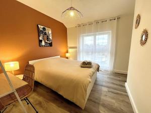 a bedroom with a large bed and a window at Le Quartz Jaune terrasse / Bourg-de-Péage in Bourg-de-Péage