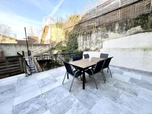 a wooden table and chairs on a patio at Le Quartz Jaune terrasse / Bourg-de-Péage in Bourg-de-Péage