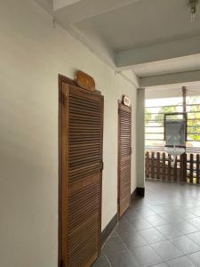 Habitación con 2 puertas de madera y TV. en Thakhek Travel Lodge, en Thakhek