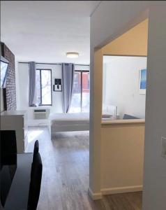 ein weißes Zimmer mit einem Bett und einem Fenster in der Unterkunft Cozy Studio! Upper East Side! in New York