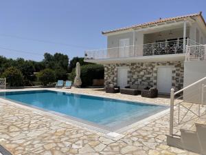 a villa with a swimming pool in front of a house at Luxurious Villa in Peloponnese with Swimming Pool in Kamária