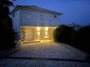 a house with lights on the front of it at Luxurious Villa in Peloponnese with Swimming Pool in Kamária