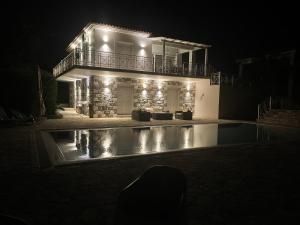 a house lit up at night with a swimming pool at Luxurious Villa in Peloponnese with Swimming Pool in Kamária