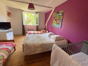 a bedroom with two beds and a purple wall at Holiday Home in Moëlan near Kerfany Beach in Moëlan-sur-Mer