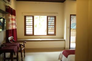 Habitación con ventana con banco y mesa en Casa Marari, en Mararikulam