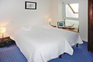 Cama blanca en habitación con ventana en Holiday home with sea view and panoramic view, Larmor-Baden, en Larmor-Baden