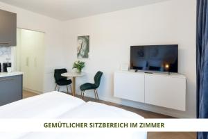 a bedroom with a bed and a flat screen tv at Apartment Wahnfried No5 - zentrales Cityapartment Küche mit Duschbad - 300m zur Fussgängerzone in Bayreuth