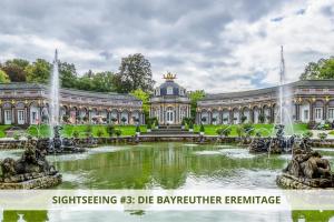 a large building with a fountain in front of a pond at Apartment Wahnfried No5 - zentrales Cityapartment Küche mit Duschbad - 300m zur Fussgängerzone in Bayreuth