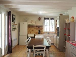 ヴェゾン・ラ・ロメーヌにあるHoliday homes, Vaison-la-Romaineのキッチン(テーブル、椅子、冷蔵庫付)