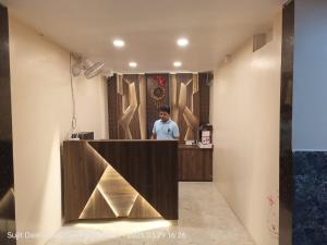 a man standing at a counter in a room at Hotel Santosh Inn Puri - Jagannath Temple - Lift Available - Fully Air Conditioned in Puri