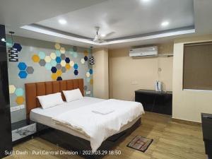 1 dormitorio con cama y pizarra en Hotel Santosh Inn Puri - Jagannath Temple - Lift Available - Fully Air Conditioned en Puri