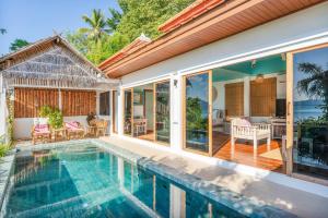 a house with a swimming pool and a patio at Soul Villas by The Beach - Phuket in Panwa Beach