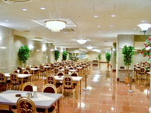 a dining hall with tables and chairs in a restaurant at Yonago Universal Hotel in Yonago