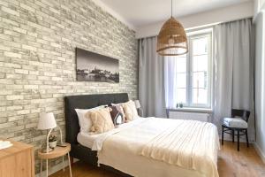 een slaapkamer met een bed en een bakstenen muur bij Smile Apartments Center Kraków Old Town in Krakau