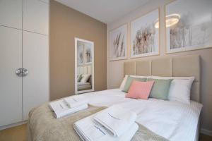 a bedroom with a large bed with two towels on it at Rogowo Pearl Apartamenty in Rogowo