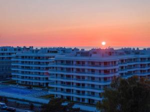 a view of a building with the sunset in the background at Rogowo Pearl Apartamenty in Rogowo
