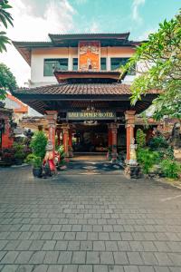 una persona sentada frente a un edificio en Bali Summer Hotel by Amerta, en Kuta