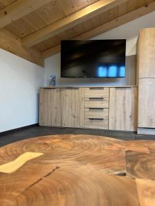ビショフスヴィーゼンにあるFerienwohnung Hirnsberglehenの薄型テレビが備わるウッドフロアの客室です。