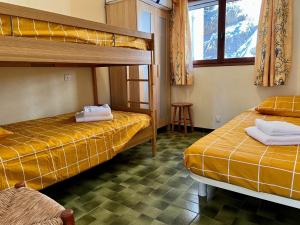 Cette chambre comprend 2 lits superposés et une table. dans l'établissement Charming gites in Lavandou walking distance to beach, au Lavandou