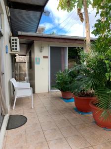 a patio with a white chair and some plants at City Home Tahiti in Papeete
