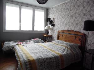 a bedroom with a bed with a blanket on it at appartement pour famille amis ou colègue in Cholet