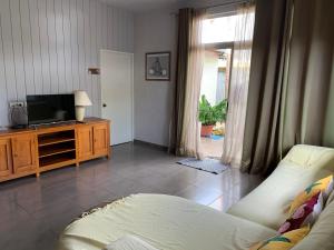 a living room with a couch and a television at City Home Tahiti in Papeete