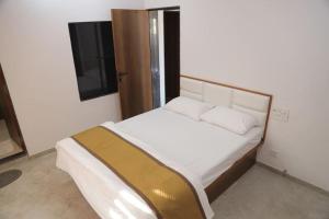 1 dormitorio con 1 cama y TV en una habitación en Gulmohar Homes en Udaipur