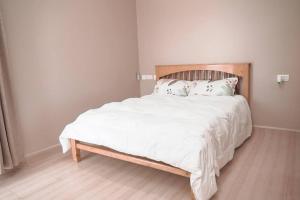 ein Schlafzimmer mit einem großen Bett mit weißer Bettwäsche und Kissen in der Unterkunft Charming Waterside Escape in Entebbe