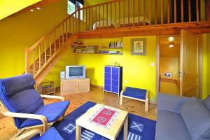 sala de estar con sofá y escalera en Holiday flat on small holiday farm with indoor pool many activities Kindwiller, en Pfaffenhoffen