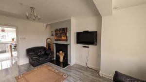 ein Wohnzimmer mit einem Kamin und einem TV in der Unterkunft Relaxing 3 Bedroom Norwich Haven in Norwich