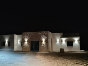 un bâtiment vide la nuit avec des lumières allumées dans l'établissement I trulli di Uma, à Carovigno