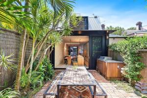 a backyard with palm trees and a house at Cozy 3 Bedroom House Annandale in Sydney