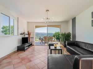 a living room with a couch and a television at Mesmerising villa in Les Vans with private pool in Les Vans