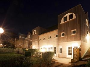 ein großes Gebäude in der Nacht mit Straßenbeleuchtung in der Unterkunft Holiday resort Golfe du Morbihan Larmor Baden acc for 4 pers in Larmor-Baden