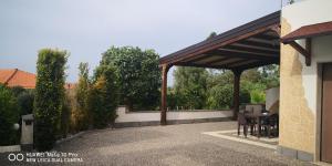 einen Pavillon mit einem Tisch und Stühlen auf einer Terrasse in der Unterkunft Villa Relax giardino a Brucoli Siracusa e Catania in Brucoli