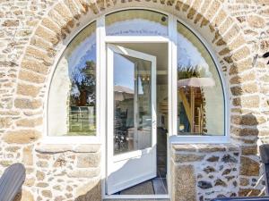 una ventana arqueada con una puerta blanca en un edificio de piedra en Welcoming Holiday Home in Brainville with Fenced Garden, en Brainville
