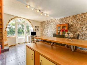 sala de estar con mesa y pared de piedra en Welcoming Holiday Home in Brainville with Fenced Garden, en Brainville