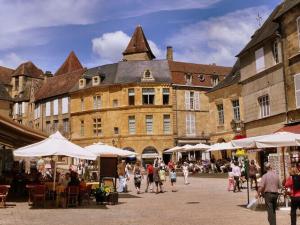 un grupo de personas caminando por un mercado frente a un edificio en Luxury villa near the cute towns of Sarlat and Rocamadour en Lanzac