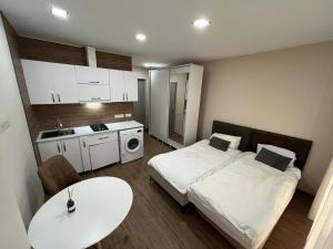 a room with two beds and a table and a kitchen at HOTEL PARIS in Batumi