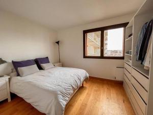 een slaapkamer met een groot bed en een raam bij Appartement tout confort avec vue in Saint-Denis