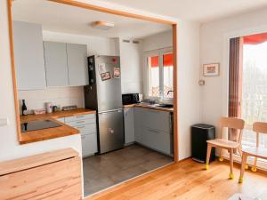 een keuken met een roestvrijstalen koelkast en een tafel bij Appartement tout confort avec vue in Saint-Denis