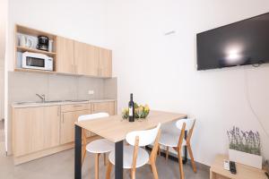 a kitchen and dining room with a wooden table and chairs at Apartments Medena in Trogir