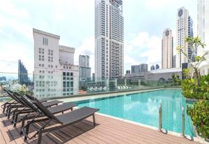 une piscine sur le toit d'un immeuble avec des chaises dans l'établissement OYO 90952 Quill Residences Kuala Lumpur by Oyo, à Kuala Lumpur