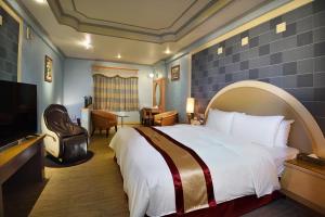 um quarto de hotel com uma cama e uma televisão de ecrã plano em Natoli Motel em Tainan